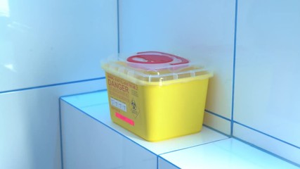Putting a biomedical waste into a special sharps container
