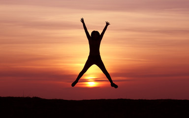 Silhouette of a girl jumping at sunset, athletic girl, happy, incredible sunset