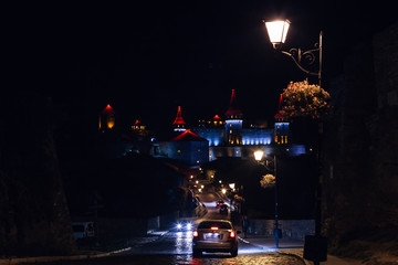 night castle. cars and road illuminated by street lantern
