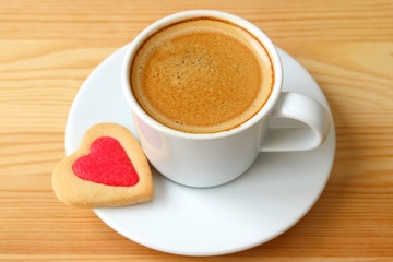 Closed up espresso coffee with heart shaped cookies served on wooden table