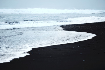 Ocean wave at black beach.