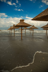 Beach with straw umbrellas under water