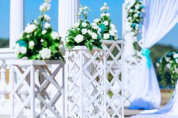 wooden stands and bouquets of flowers in front of the arch