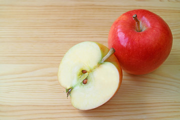 Fresh red apple whole fruit and its cross section on wooden table with copy space 