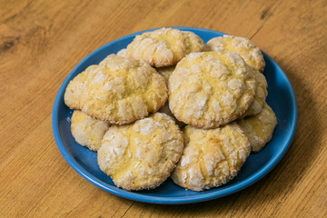 Homemade Lemon Sugar cookies stacked on the blue saucer at wooden background