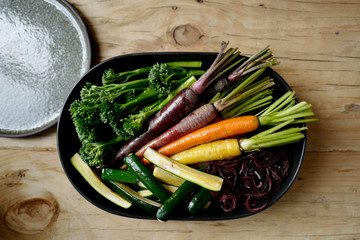 Healthy cooking with fresh vegetables on wooden table in oval bowls 