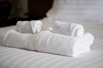 Fototapeta na wymiar Stack of white bath towels on bed sheet