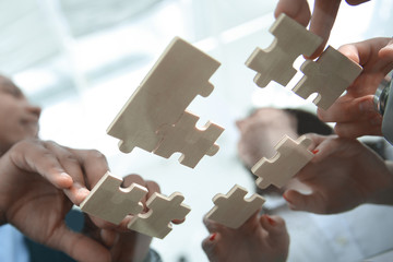 bottom view. business team folding puzzle pieces. .