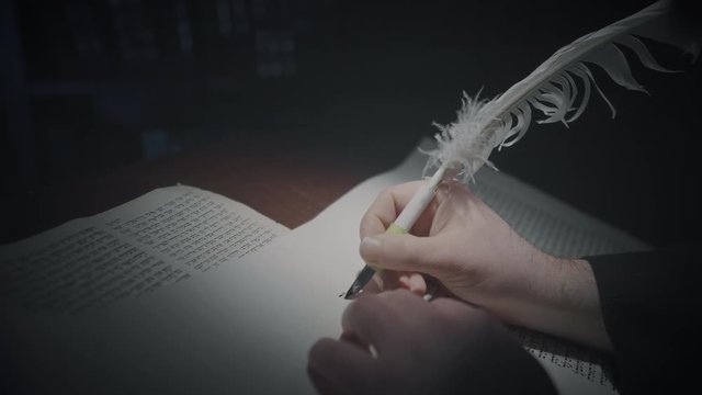 Cinematic shot of the man writing a Torah scroll