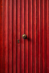Red wooden retro door with small handle and keyhole. Minimalism concept. Background.