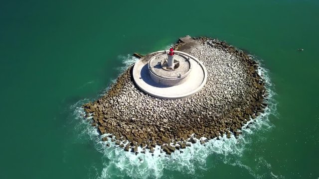 Aerial, orbit, drone shot, of Bugio lighthouse, on the atlantic sea, on a sunny day, near Oeiras coast and Tejo river, in Lisbon, Portugal