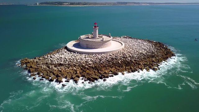 Aerial, orbit, drone shot, around Bugio lighthouse, on a rocky island, in the middle of the atlantic ocean, on a sunny day, near Oeiras coast and Tejo river, in Lisbon, Portugal