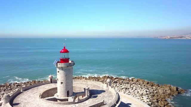 Aerial, drone shot, over Bugio lighthouse, on a rocky island, tilting up towards the atlantic ocean, on a sunny day, near Oeiras coast and Tejo river, in Lisbon, Portugal