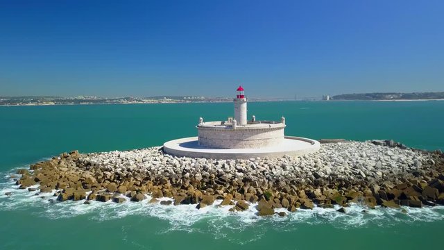 Flyover drone shot, of Bugio lighthouse, on a rocky island, at the atlantic ocean, on a sunny day, a aerial view, near the Oeiras coast and Tejo river, in Lisbon, Portugal
