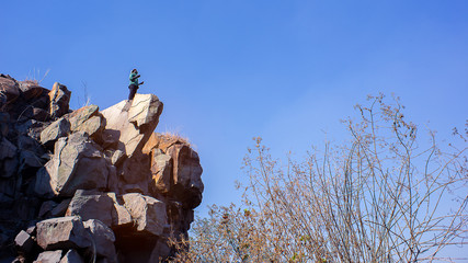 African Man praying on top of mountain.16:9 style