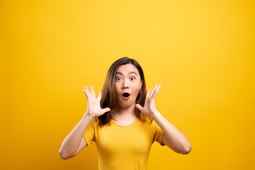 Portrait of excited woman isolated over yellow background