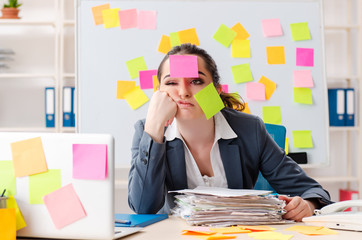 Young female employee in conflicting priorities concept 