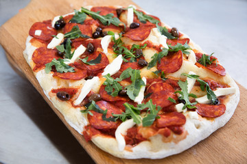 Freshly baked salami pizza on the board