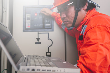 Obraz premium engineer or electrician holding laptop for inspect and checking main distribution board by wifi technology ;smart technology for operation of solar power plant by smart operator
