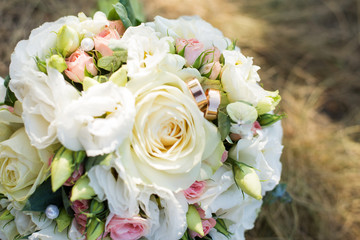 Wedding background . The bride's bouquet with white flowers and rings on the grass. declaration of love. Wedding card, day details