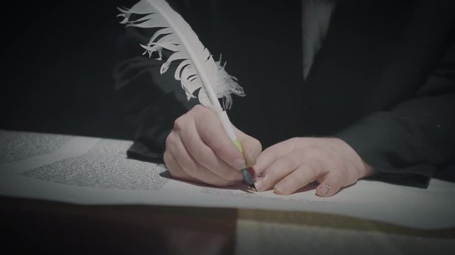 Cinematic shot of the man writing a Torah scroll