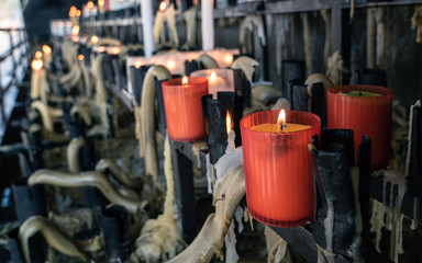 Red candles melting down in a cementery 