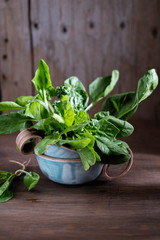 green fresh bunch of spinach in a beautiful cup on a wooden background