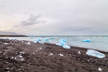 Fototapeta na wymiar A view of Jokulsalron Glacier in southern Iceland and ice falling to the ocean, Iceland