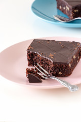 Homemade dark chocolate vegan brownie cake with nuts plate light background. Selective focus.