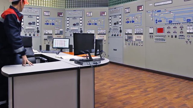 engineer approaches main control shield of gas compressor station and checks LEDs