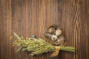 Naklejka na ściany i meble Rustic style Easter decoration - nest with eggs and bouquet of dry herbs on vintage wooden background