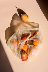 plastic shopping bag with fruits. Conceptual still life after the shopping with artistic shadows.