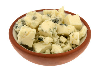 Small bowl filled with chunks of blue cheese on a white background