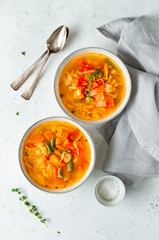 Spring vegetable soup with chicken stock for two person on white table. Top view, copy space.