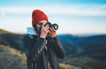 hipster tourist girl hold in hands take photography click on modern photo camera, photographer look...
