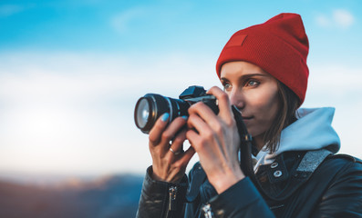 hipster tourist girl hold in hands take photography click on modern photo camera, photographer look on camera technology, journey landscape vacation concept, sun flare mountain - obrazy, fototapety, plakaty