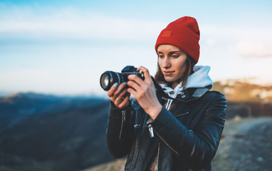 hipster tourist girl hold in hands take photography click on modern photo camera, photographer look...