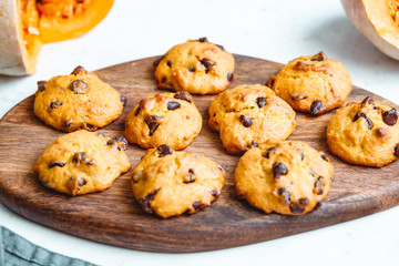 Pumpkin cookies with chocolate chips made from cake mix on a wooden tray.