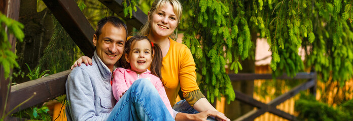 Fototapeta premium Portrait of happy family of three. Concept of happy family relations and carefree leisure time