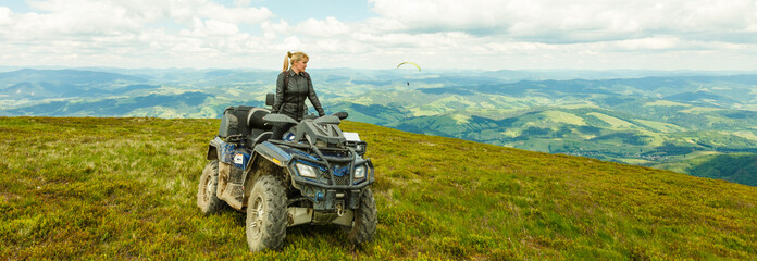 Happy woman riding a quad bike at the top of a mountain © Angelov