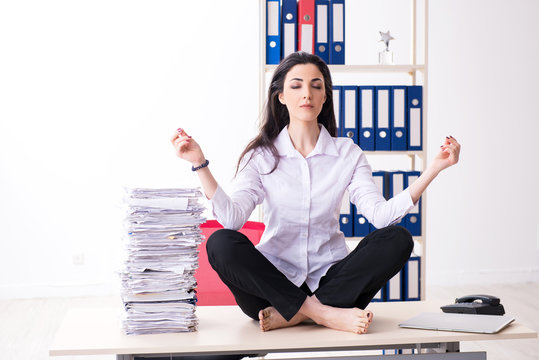Young female employee doing exercises in the office 