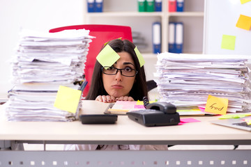 Young female employee in conflicting priorities concept 