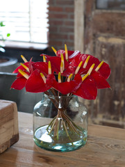 Red flowers bouquet on a table in interior