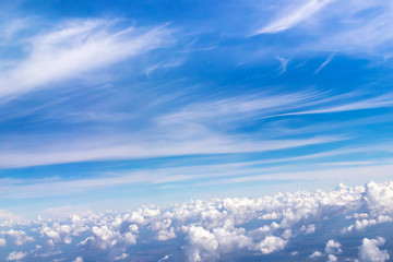 Fototapeta na wymiar Blue sky with fluffy clouds; soft cirrus and stratocumulus white clouds in the sky. Beautiful view seen from the plane.