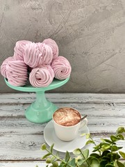 Raspberry pink marshmallow on a bright stand, HOT COFFEE with foam in a white Cup.   	