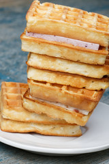 Stack of Viennese waffles on wooden background. Waffles on a white plate, wooden rough blue background.