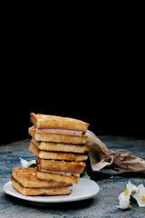 Stack of Viennese waffles on wooden background. Waffles on a white plate, wooden rough blue background.