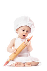 ten months old baby in a suit of the cook surprised and smiling in the kitchen. Small kid as a little cook or scullion make pizza in chef suit. Cooking child lifestyle concept. Toddler playing.