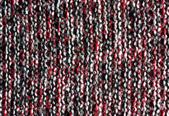 Variegated knitted fabric. Motley knit texture. Background of wool melange cloth. Backdrop for wallpaper and other elements of your design. Horizontal orientation.