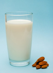 glass of almond milk on blue background